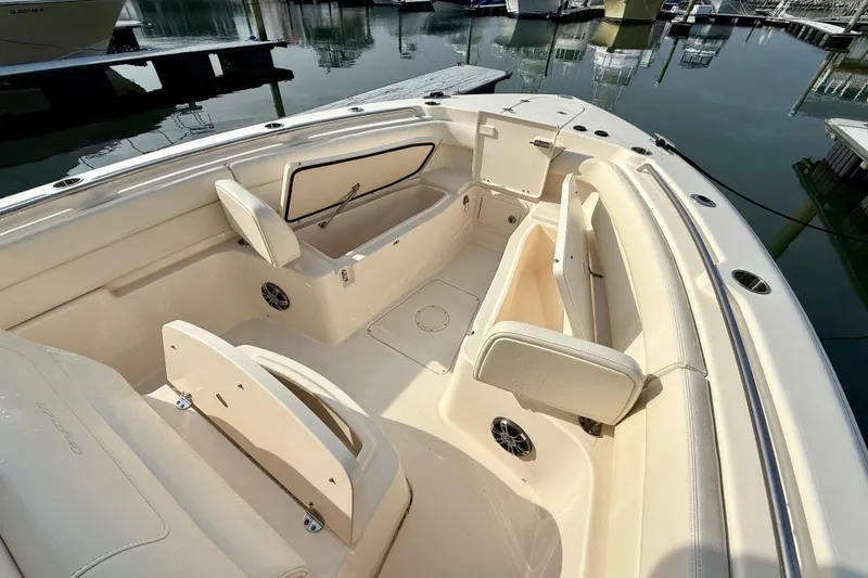 Slide: The Image of 2022 Grady-White Canyon 271 boat interior with seating and storage, docked at marina. - 12
