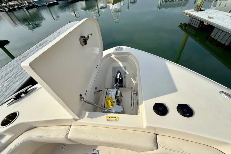 Slide: The Image of 2022 Grady-White Canyon 271 boat anchor compartment open at marina. - 15