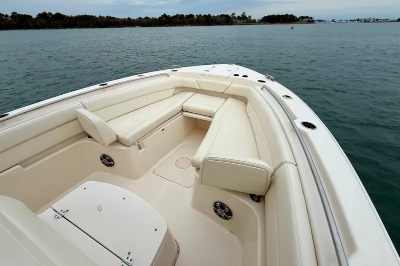 Slide: The Image of 2022 Grady-White Canyon 271 boat interior with white seating, on calm water. - 17