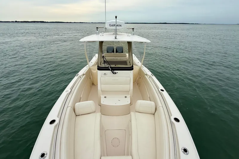 Slide: The Image of 2022 Grady-White Canyon 271 boat on calm water, showcasing spacious deck and seating. - 18