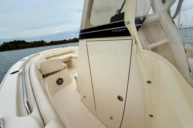 Slide: The Image of 2022 Grady-White Canyon 271 boat interior with seating and console, on calm water. - 20