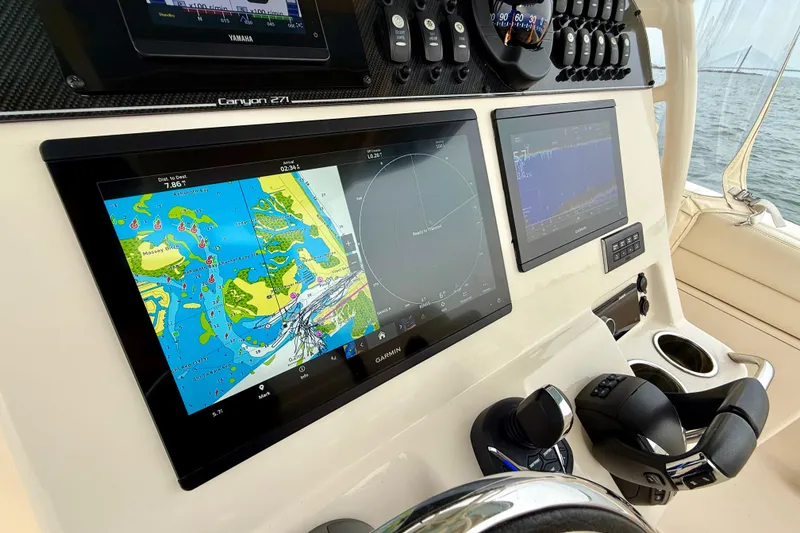Slide: The Image of 2022 Grady-White Canyon 271 boat dashboard with navigation and control systems. - 25