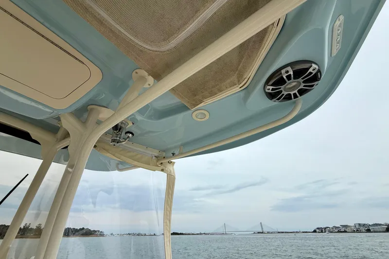 Slide: The Image of 2022 Grady-White Canyon 271 boat interior with speaker, ocean view, and distant bridge. - 33