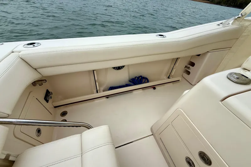 Slide: The Image of 2022 Grady-White Canyon 271 boat interior with white seating and storage compartments. - 37