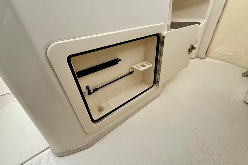 Slide: The Image of 2022 Grady-White Canyon 271 storage compartment with open door, showcasing interior features. - 41