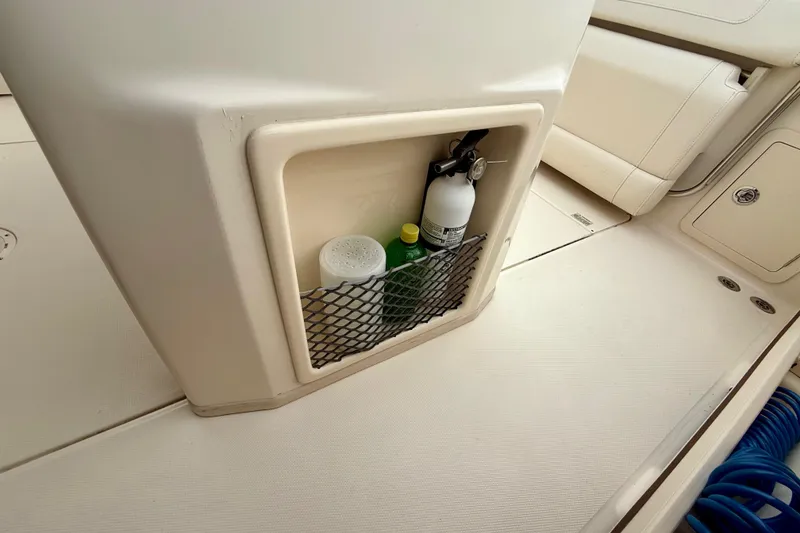 Slide: The Image of Storage compartment on 2022 Grady-White Canyon 271 boat with fire extinguisher and supplies. - 44