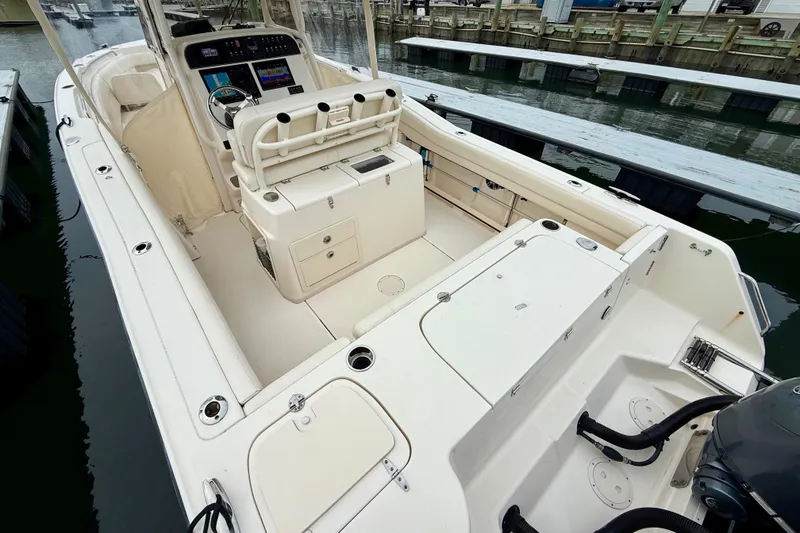 Slide: The Image of 2022 Grady-White Canyon 271 boat interior, featuring helm and seating area at dock. - 8