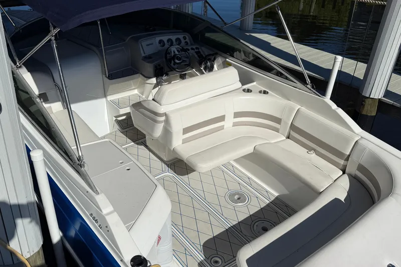Slide: The Image of 1999 Formula 280 Sun Sport boat interior with white seating, docked by calm water. - 5