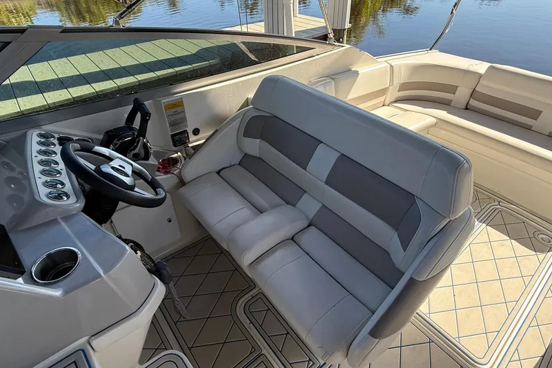 Slide: The Image of 1999 Formula 280 Sun Sport boat interior with white seating, docked by calm water. - 6