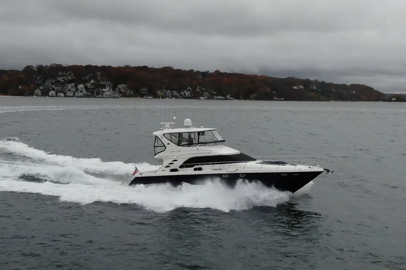 The Image of 2004 Sea Ray 560 Sedan Bridge cruising on a scenic lake with autumn foliage. - 0