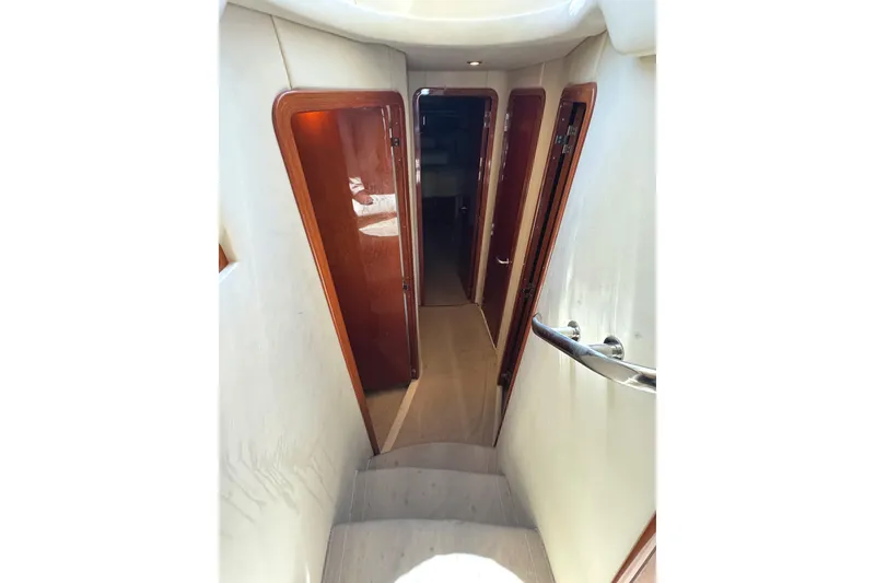 Slide: The Image of Interior hallway of 2004 Sea Ray 560 Sedan Bridge yacht with wooden doors and handrail. - 18