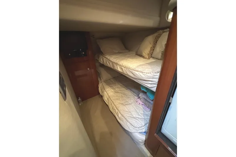 Slide: The Image of 2004 Sea Ray 560 Sedan Bridge cabin with cozy bunk beds and wooden cabinetry. - 19