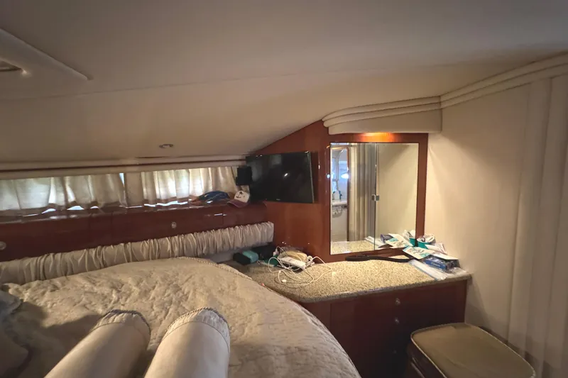 Slide: The Image of 2004 Sea Ray 560 Sedan Bridge cabin interior with bed, mirror, and TV. - 26