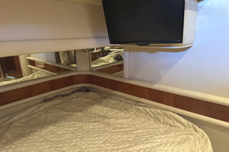 Slide: The Image of Cozy cabin interior of 2004 Sea Ray 560 Sedan Bridge with TV and bedding. - 30