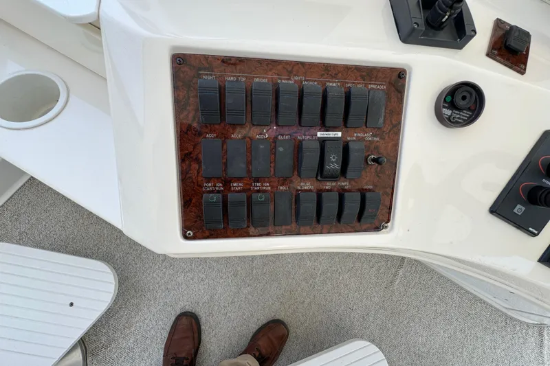 Slide: The Image of Control panel of a 2004 Sea Ray 560 Sedan Bridge yacht, featuring various switches and controls. - 44