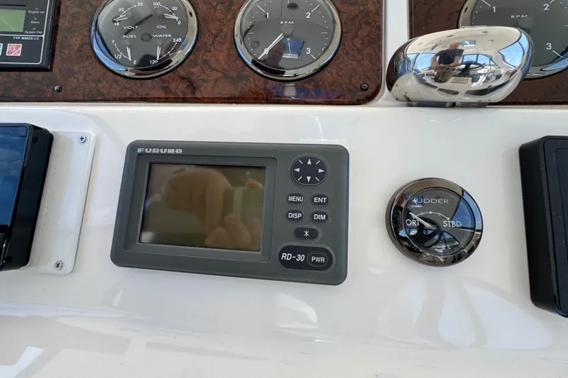 Slide: The Image of Control panel of a 2004 Sea Ray 560 Sedan Bridge with gauges and Furuno display. - 48