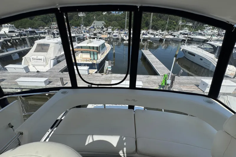 Slide: The Image of 2004 Sea Ray 560 Sedan Bridge interior view overlooking marina with multiple boats docked. - 49