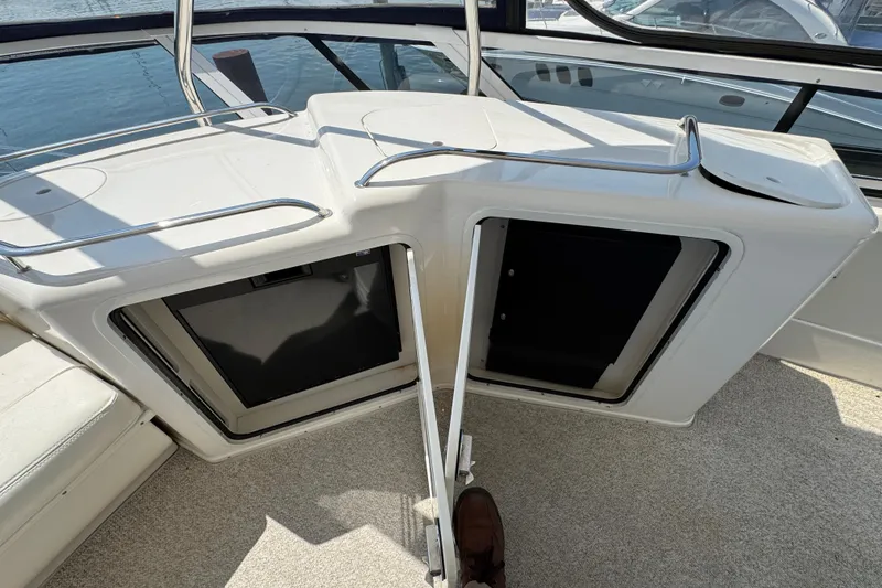 Slide: The Image of 2004 Sea Ray 560 Sedan Bridge interior with open storage compartments and railing. - 51