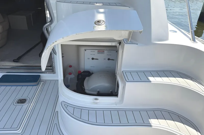 Slide: The Image of 2004 Sea Ray 560 Sedan Bridge engine compartment with open hatch, docked by water. - 54