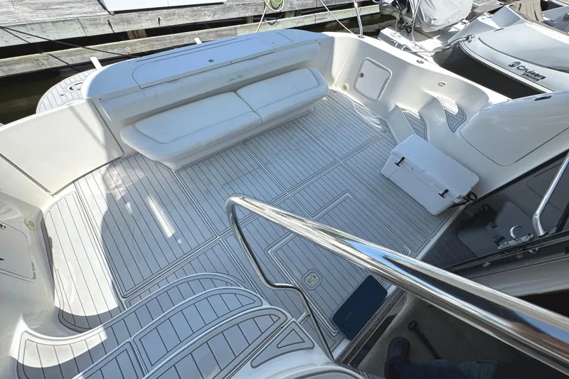 Slide: The Image of 2004 Sea Ray 560 Sedan Bridge yacht deck with white seating and sleek design. - 56