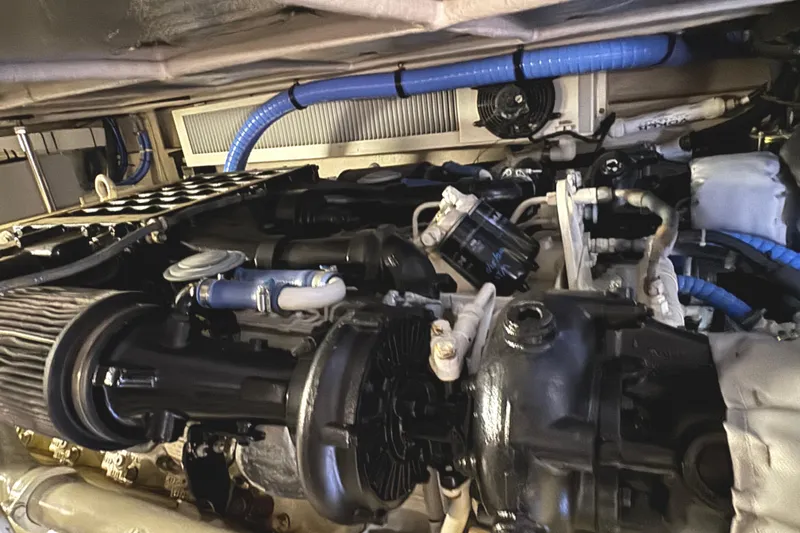 Slide: The Image of Engine compartment of a 2004 Sea Ray 560 Sedan Bridge with visible components and blue hoses. - 60