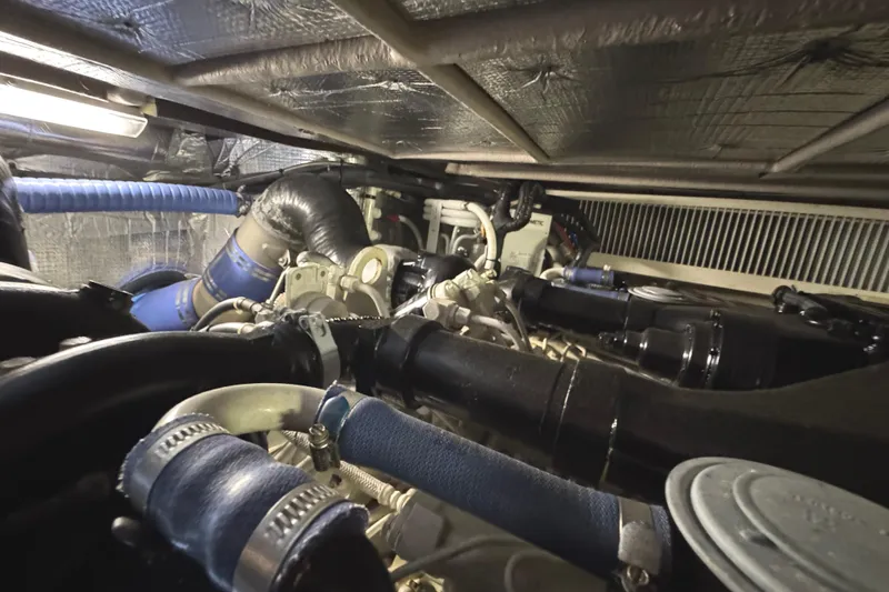 Slide: The Image of Engine room of 2004 Sea Ray 560 Sedan Bridge with visible hoses and components. - 62