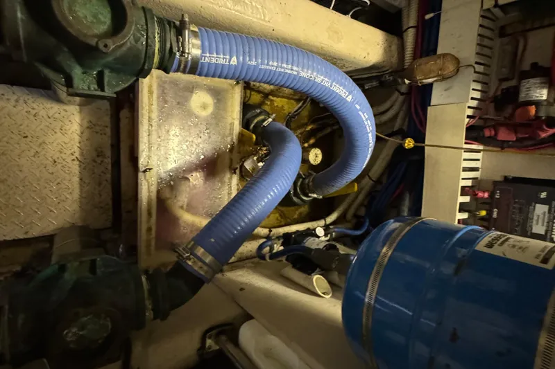 Slide: The Image of Engine room of a 2004 Sea Ray 560 Sedan Bridge with blue hoses and mechanical components. - 66