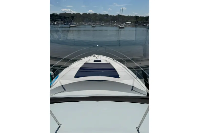 Slide: The Image of 2004 Sea Ray 560 Sedan Bridge yacht on calm waters, viewed from the deck. - 77