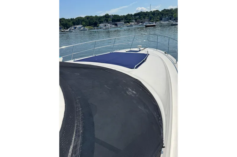 Slide: The Image of 2004 Sea Ray 560 Sedan Bridge yacht on calm water, featuring a spacious deck. - 78