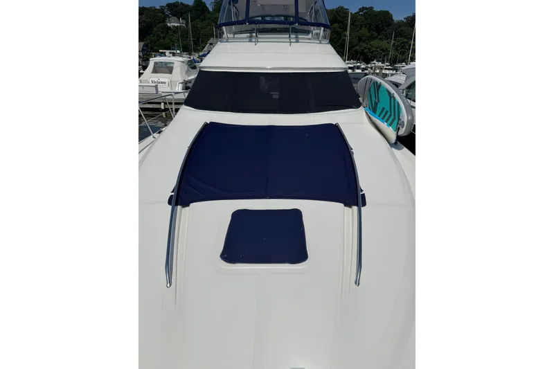 Slide: The Image of 2004 Sea Ray 560 Sedan Bridge yacht with blue sunshade, docked at marina. - 81