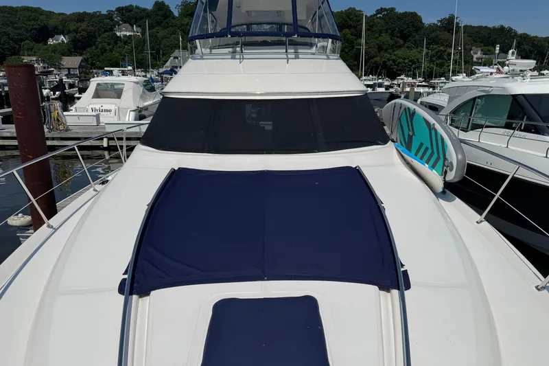 Slide: The Image of 2004 Sea Ray 560 Sedan Bridge yacht docked, featuring a paddleboard on deck. - 82