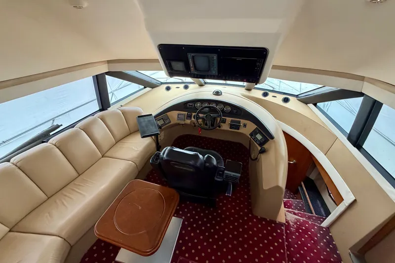 Slide: The Image of 1999 Carver 530 Voyager Pilothouse interior with helm, leather seating, and navigation equipment. - 10