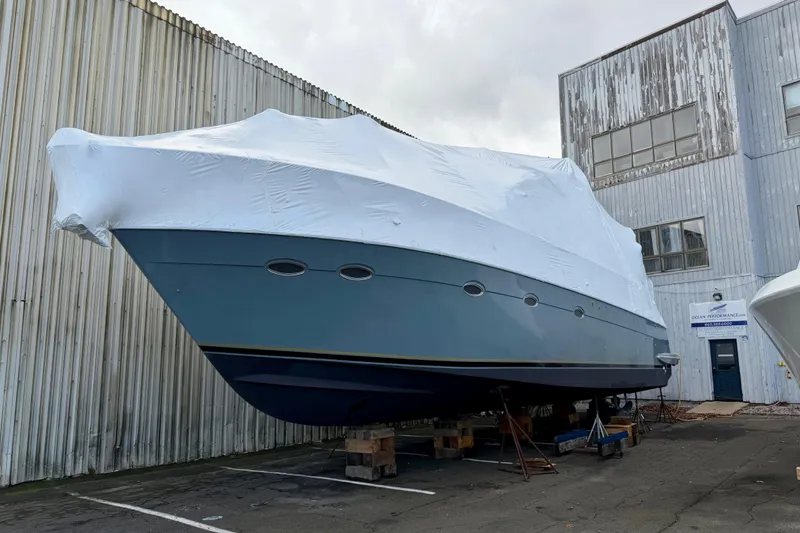 Slide: The Image of 1999 Carver 530 Voyager Pilothouse yacht covered and docked near industrial building. - 5