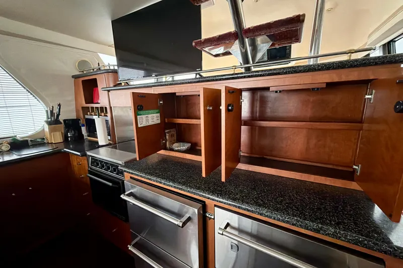 Slide: The Image of Interior of 1999 Carver 530 Voyager Pilothouse kitchen with open cabinets and modern appliances. - 20
