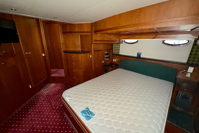 Slide: The Image of Luxurious bedroom interior of 1999 Carver 530 Voyager Pilothouse yacht with wood paneling. - 27