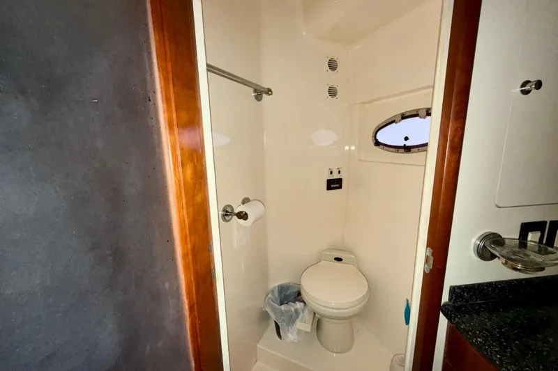 Slide: The Image of Bathroom in 1999 Carver 530 Voyager Pilothouse yacht, featuring toilet and porthole window. - 30