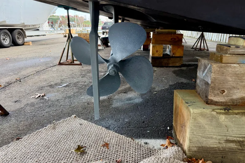 Slide: The Image of 1999 Carver 530 Voyager Pilothouse propeller on dry dock, supported by wooden blocks. - 52