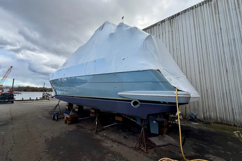 Slide: The Image of 1999 Carver 530 Voyager Pilothouse yacht covered and docked near a waterfront. - 8