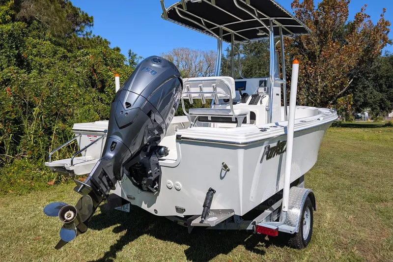 Slide: The Image of 2026 Parker 18SE Center Console boat with outboard motor on trailer, parked on grass. - 15