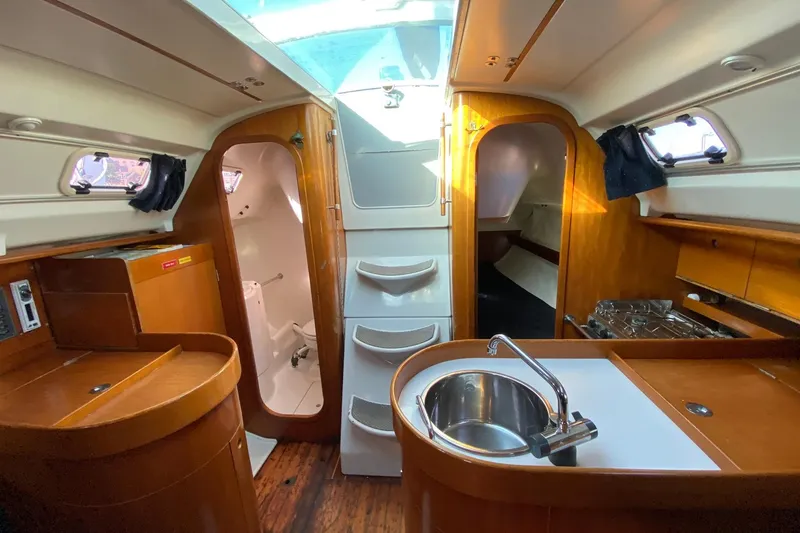 Slide: The Image of Interior of 1993 Beneteau First 310 sailboat with kitchen and wooden cabinetry. - 11