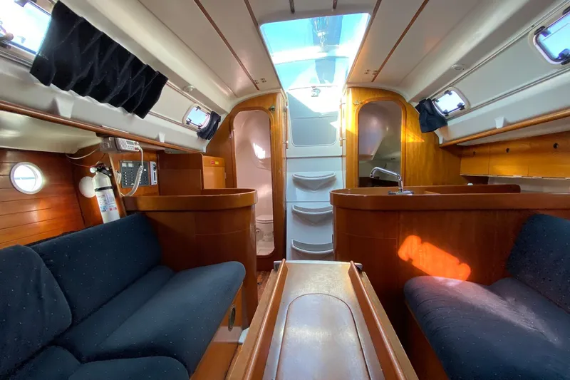 Slide: The Image of Interior of 1993 Beneteau First 310 sailboat with wood finish and seating area. - 12