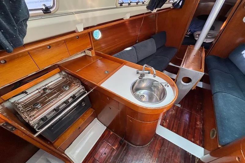 Slide: The Image of Interior of 1993 Beneteau First 310 sailboat with kitchen and seating area. - 13