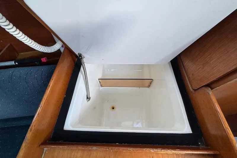 Slide: The Image of Interior sink of 1993 Beneteau First 310 sailboat, featuring wooden trim and flexible faucet. - 20