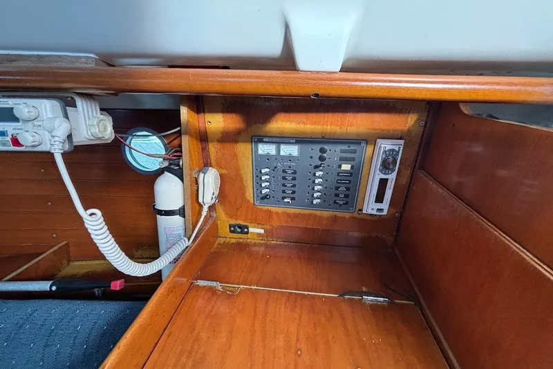 Slide: The Image of Control panel inside a 1993 Beneteau First 310 sailboat, featuring switches and communication equipment. - 21