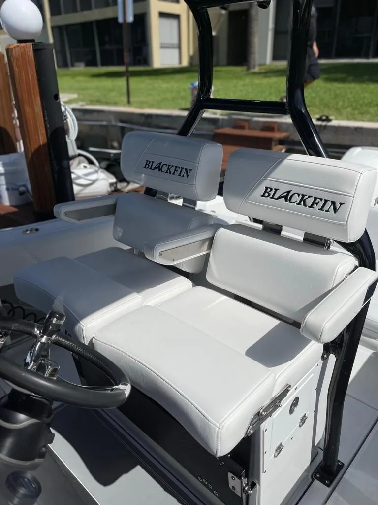 Slide: The Image of 2019 Blackfin 272 CC boat with white cushioned seating and steering wheel. - 16