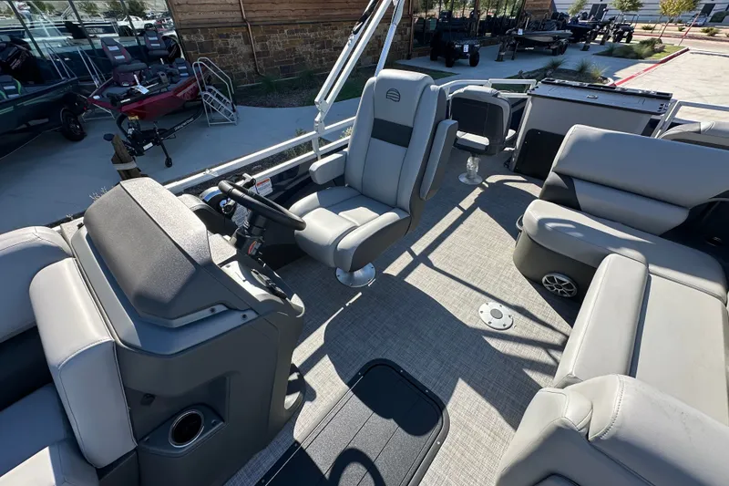 Slide: The Image of 2026 Sun Tracker SportFish 22 XP3 pontoon boat interior with plush seating and steering console. - 18