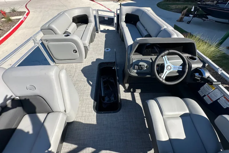 Slide: The Image of 2026 Sun Tracker SportFish 22 XP3 pontoon boat interior with gray seating and steering console. - 19