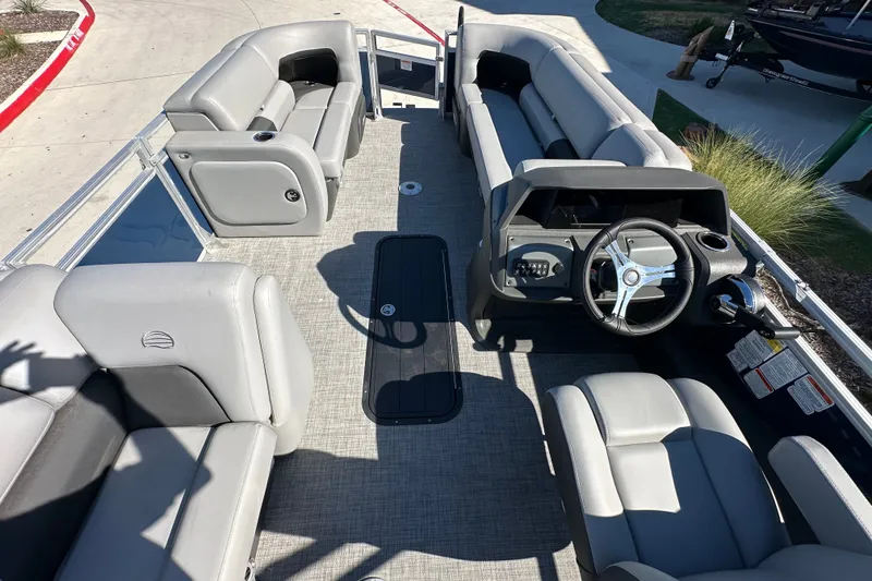 Slide: The Image of 2026 Sun Tracker SportFish 22 XP3 pontoon boat interior with gray seating and steering console. - 26