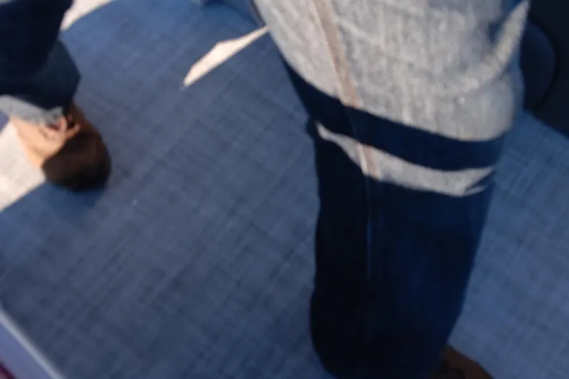 Slide: The Image of Blurred view of a person standing on a Sun Tracker SportFish 22 DLX boat deck. - 74