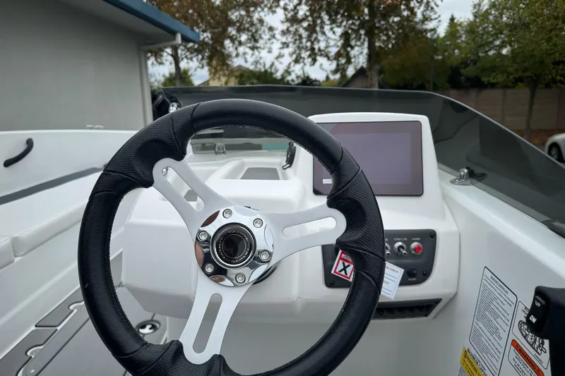 Slide: The Image of Steering wheel and dashboard of 2026 Tahoe T18 boat, featuring modern controls and display. - 23